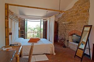 a bedroom with a bed and a stone wall at Nascar Hotel in Santa Maria Navarrese +37 photos