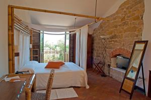 1 dormitorio con cama y pared de piedra en Nascar Hotel, en Santa Maria Navarrese