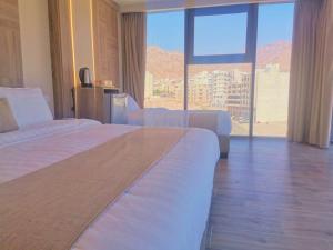 una camera d'albergo con due letti e una grande finestra di ALENA HOTEL ad Aqaba