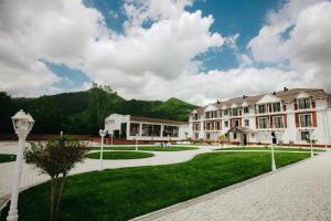ein großes Gebäude mit grünem Rasen davor in der Unterkunft Castle Resort Spa Hotel in İsmayıllı