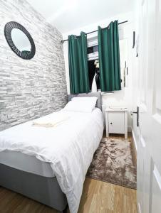 a bedroom with a bed and a brick wall at The Saxon Rooms in Barking