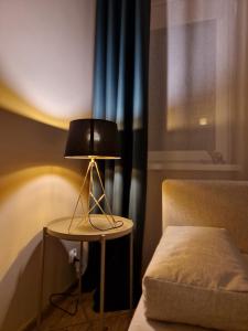 lampa siedząca na stole obok łóżka w obiekcie 91WrocLove Apartaments we Wrocławiu