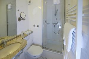 a bathroom with a shower and a toilet and a sink at Hotel Diamant in Wedel