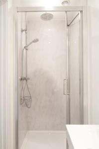 a shower with a glass door in a bathroom at The Spitfire - Renovated 3-bed house in Cheltenham, SLEEPS 8 in Cheltenham