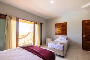 a bedroom with two beds and a window at Villa Ondas in Barra Grande