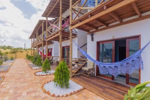 a house with a hammock outside of it at Villa Ondas in Barra Grande