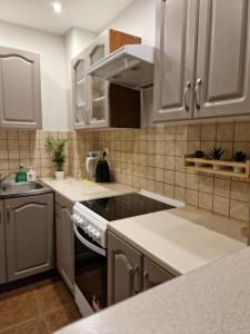 uma cozinha com armários brancos e um forno com placa de fogão em 91WrocLove Apartaments em Breslávia