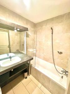 La salle de bains est pourvue d'un lavabo, d'une douche et d'une baignoire. dans l'établissement Jolie 3 pièces avec terrasse au vieux port, à 2 pas des plages et du palais., à Cannes