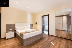 PietàにあるSeafront, Designer APT with Private Terrace & WIFI by 360 Estatesのベッドと大きな鏡のある寝室