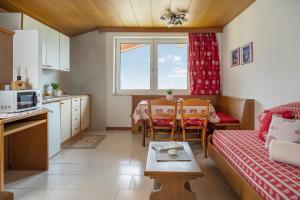 a kitchen and living room with a couch and a table at A. Paolo Apartments in Vigo di Fassa
