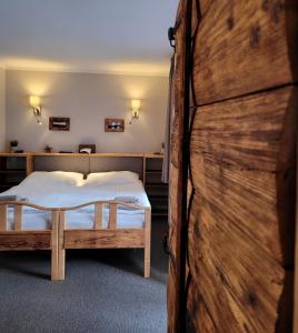 a bedroom with two beds and a wooden wall at Hotel STARÝ MLÝN in Jeseník