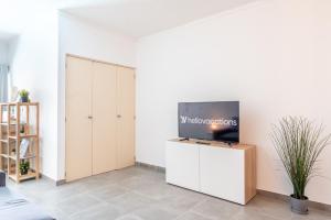 a living room with a tv on a white wall at Villa Magna - Apt- 206 by HelloVacations in Albufeira