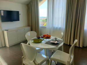 d'une salle à manger avec une table, des chaises et une fenêtre. dans l'établissement Hotel Grel, à Chiaramonte Gulfi