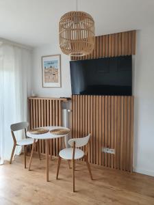 a living room with a table and chairs and a tv at LEOmare in Międzywodzie