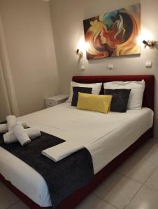 a bedroom with a large bed with white and yellow pillows at Modern Quiet Apartment in the Center of Rhodes in Rhodes Town