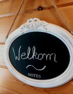a sign on a wooden table with the words welcome nodes at House Rhodopi in Maldegem
