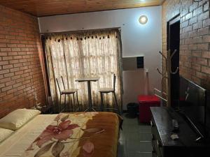 Un dormitorio con una cama y una mesa y una ventana. en Casona Rural Km 1469, en Puerto Rico