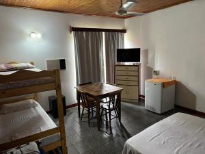 a bedroom with a bed and a table and a television at Casona Rural Km 1469 in Puerto Rico