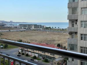 einen Balkon mit Blick auf ein Gebäude und einen Strand in der Unterkunft Park Azure Modern apartment in Baku