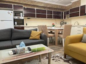 eine Küche mit 2 Sofas und einem Tisch in einem Zimmer in der Unterkunft Park Azure Modern apartment in Baku