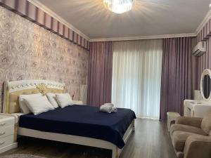 ein Schlafzimmer mit einem Bett, einem Sofa und einem Fenster in der Unterkunft Park Azure Modern apartment in Baku