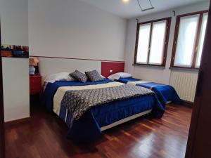 een slaapkamer met 2 bedden en 2 ramen bij Casa Vacanze La Torre in Orio al Serio