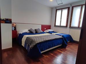 a bedroom with two beds and two windows at Casa Vacanze La Torre in Orio al Serio