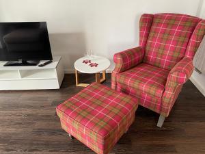 a living room with a chair and a tv at Ferienwohnung LIVONA in Bad Neuenahr-Ahrweiler