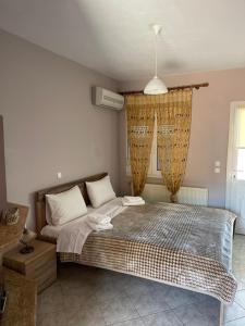 ein Schlafzimmer mit einem großen Bett und einem Fenster in der Unterkunft Agapi in Orma