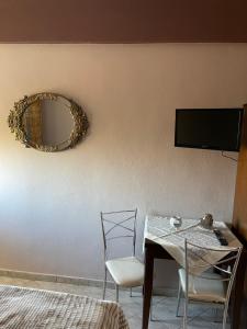 ein Esszimmer mit einem Tisch und einem Spiegel in der Unterkunft Agapi in Orma