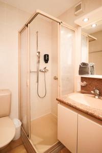 a bathroom with a shower and a toilet and a sink at Chalet La Pala in Val-d'Illiez