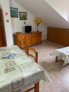 a room with two tables and a desk with a television at Marisa Mored vivienda de uso Turistico in Laspaúles