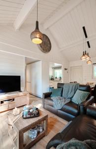 uma sala de estar com um sofá e uma televisão em Chalet D'un Ami em Somme-Leuze