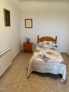 a bedroom with a bed and a table in a room at Marisa Mored vivienda de uso Turistico in Laspaúles