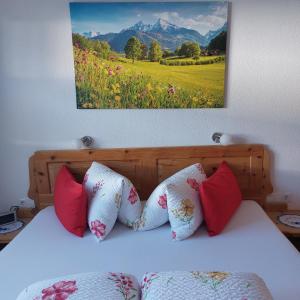 a bed with four pillows and a painting on the wall at Apart Waldesruh in Arzl im Pitztal