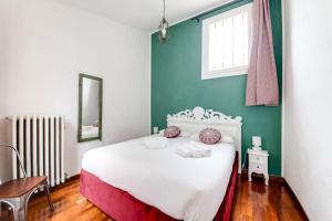 sypialnia z białym łóżkiem i niebieską ścianą w obiekcie In Piazza 'Apartments & Relax' w Rawennie