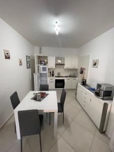 a kitchen with a white table and chairs in a room at La Casa del Nonno in Torchiara