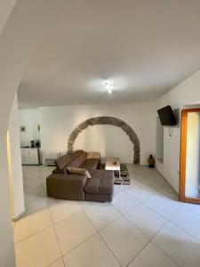 a living room with a couch and an arch at La Casa del Nonno in Torchiara