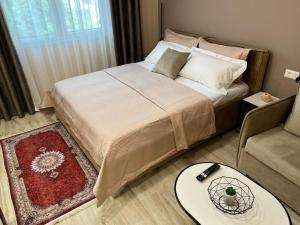 a bedroom with a bed with a table and a couch at Smart Home , Lovely Apartment in Tirana in Tirana
