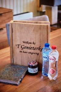 een houten doos met twee flessen water op een tafel bij Genieterke in Somme-Leuze