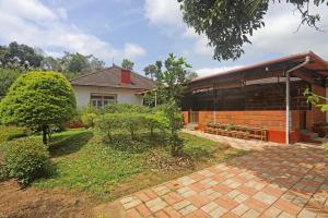 a house with a garden in front of it at Devi Villa - Plantation Retreat and Forest Getaway in Kutta