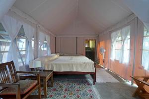 um quarto com uma cama grande num quarto com janelas em Devi Villa - Plantation Retreat and Forest Getaway em Kutta