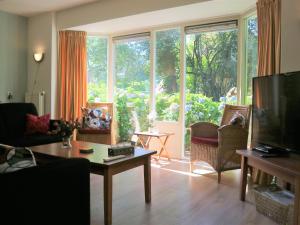 a living room with a large window and a tv at Quietly located holiday home against the Lemelerberg in Lemele