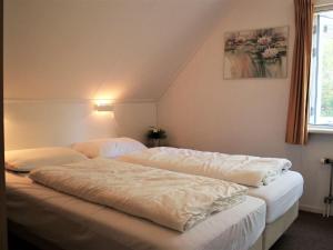 a bedroom with two beds with white sheets at Quietly located holiday home against the Lemelerberg in Lemele