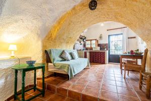 ein Wohnzimmer mit einem Sofa und einem Tisch in der Unterkunft Cuevas El Abanico - VTAR vivienda turística de alojamiento rural in Granada