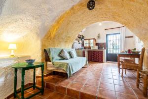 een woonkamer met een bank en een tafel bij Cuevas El Abanico - VTAR vivienda turística de alojamiento rural in Granada