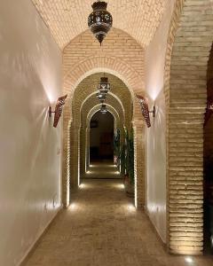 um corredor vazio com uma arcada num edifício em Dar Tozeur em Tozeur