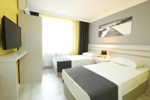 a hotel room with two beds and a flat screen tv at Kaleroom EDİRNE in Edirne