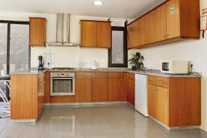 cocina grande con armarios y electrodomésticos de madera en Villa Aurélio, en Campanário
