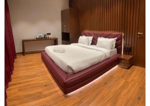 1 dormitorio con 1 cama grande y cabecero púrpura en RedHomeX Liger Villa Igatpuri, en Igatpuri